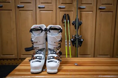 Ski boots sit on a bench and a pair of skis leans against lockers in the Tram locker room at Olympic Valley. 