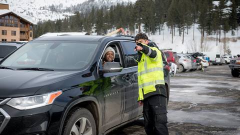 An employee directs a car to a parking place at Palisades Tahoe.