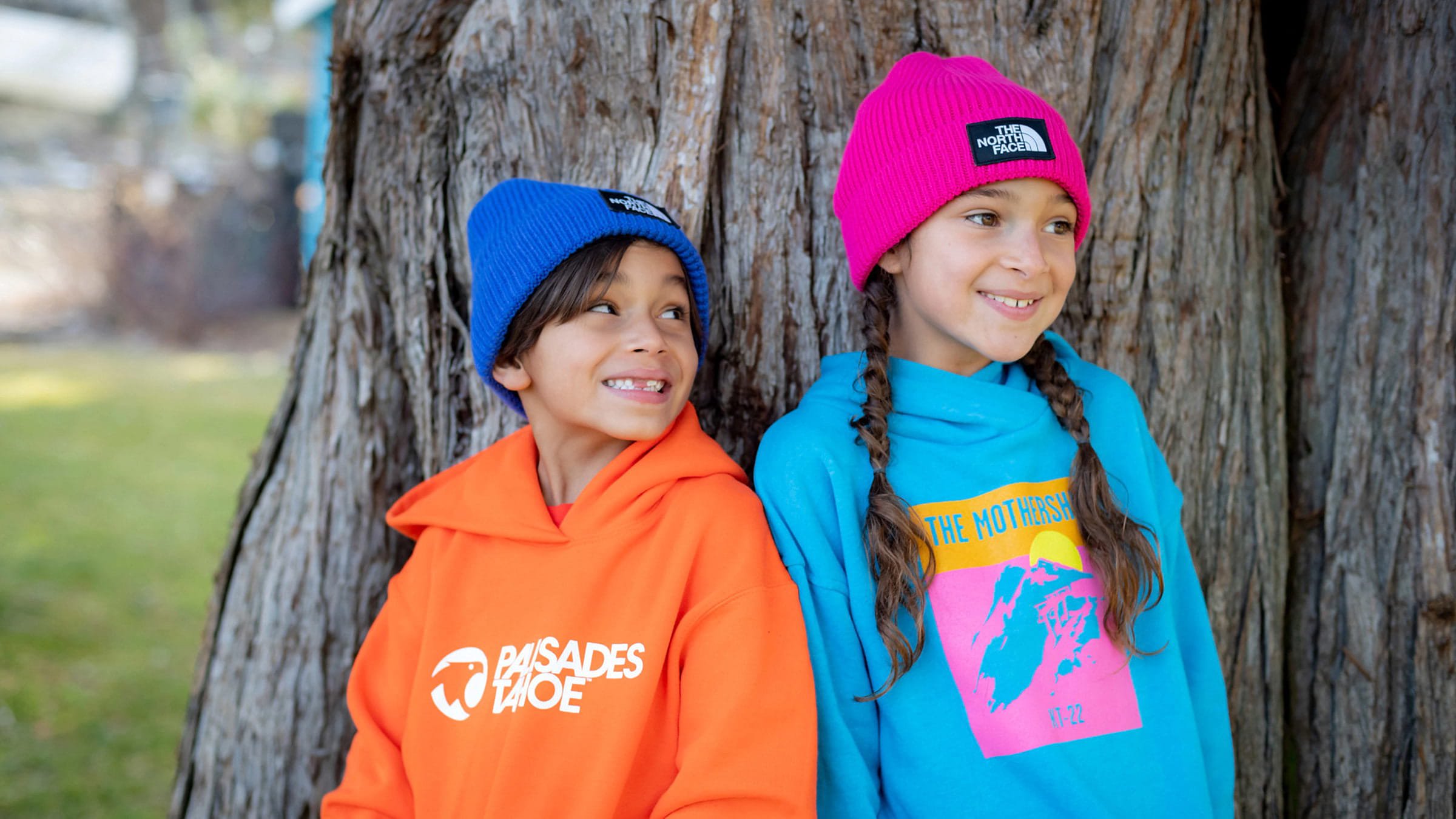 Two children wearing Palisades Tahoe logo wear outside