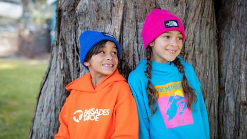 Two children wearing Palisades Tahoe logo wear outside