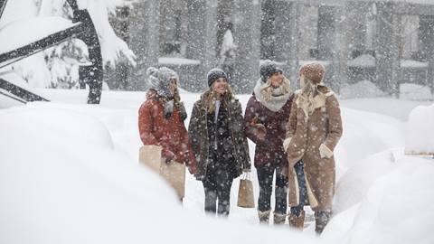 Women shopping on a snowy day in the Village at Palisades Tahoe