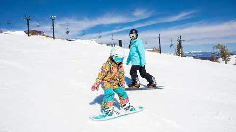 Mother and daughter snowboarding at Olympic Valley on a Spring Day
