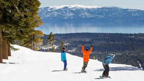 3 snowboarders riding towards Lake Tahoe at Palisades Tahoe