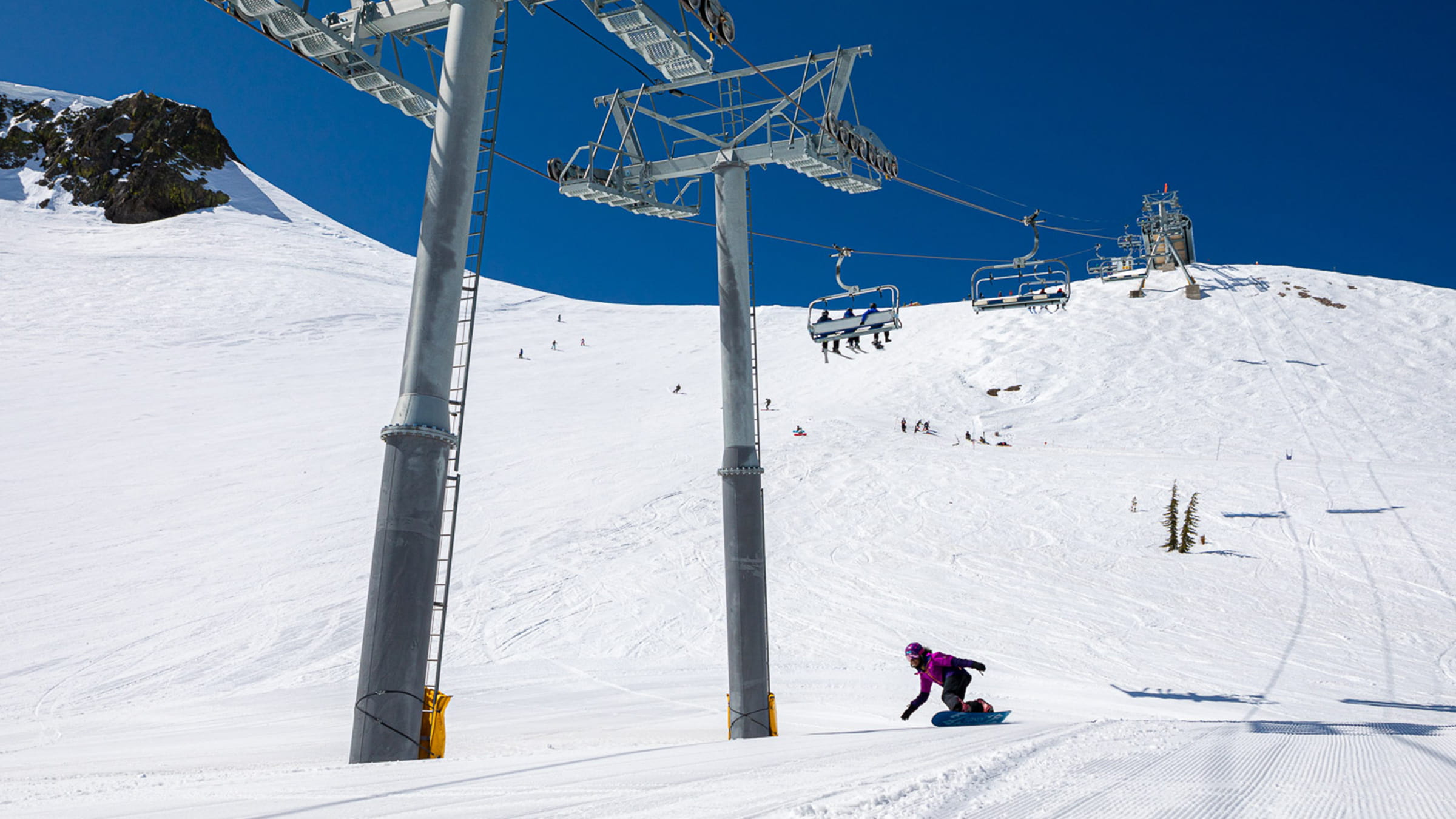 Snowboarder riding down Siberia Bowl at Olympic Valley on a sunny April day