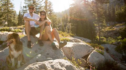 Couple resting on hike with their dog on Olympic Valley's Shirley Canyon trail