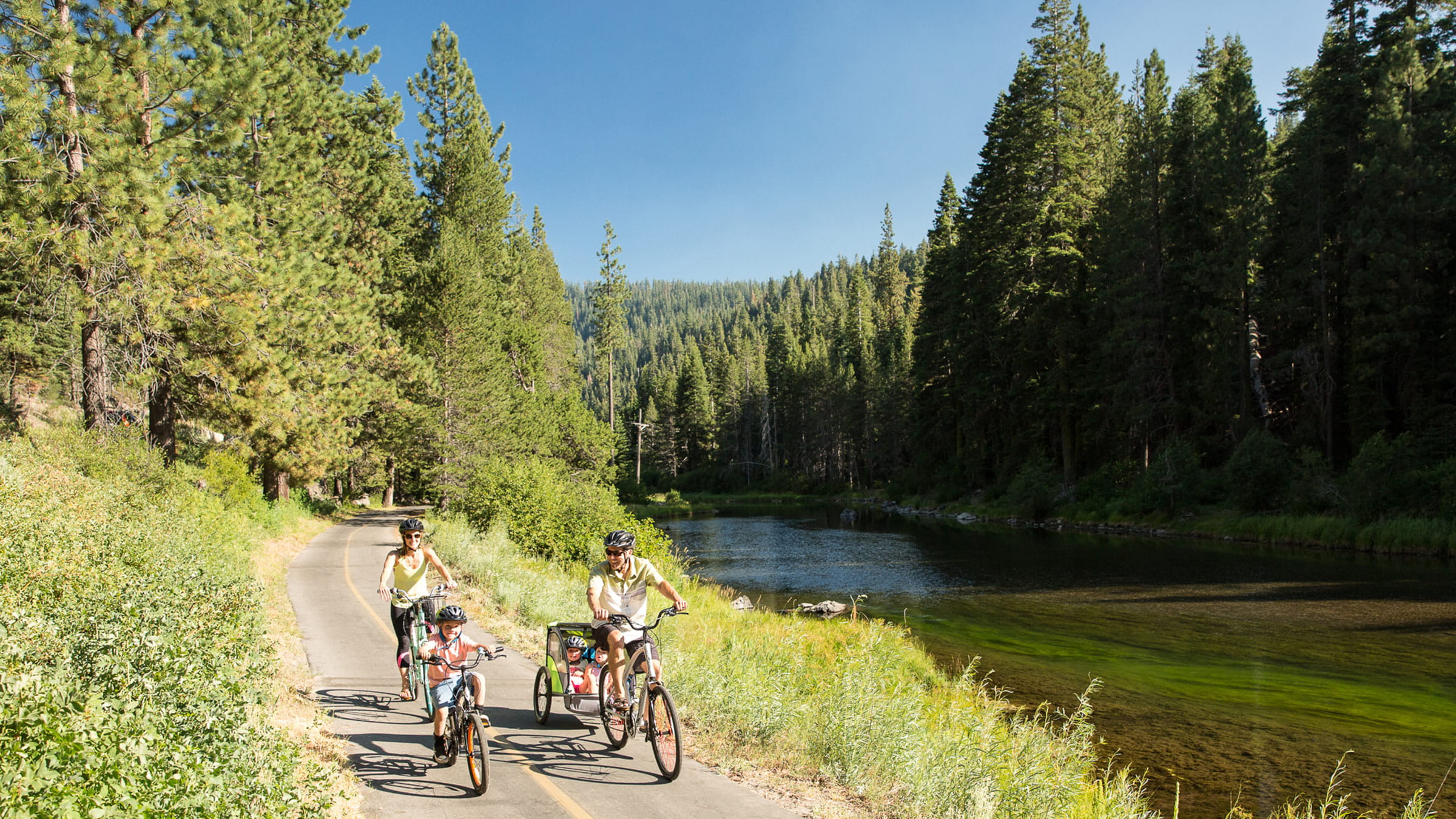 Family riding bikes along the Truckee River Path between Tahoe City and Alpine Meadows