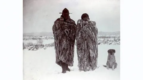 Historical photo of Washoe tribe members and their dog during winter bundled in heavy furs