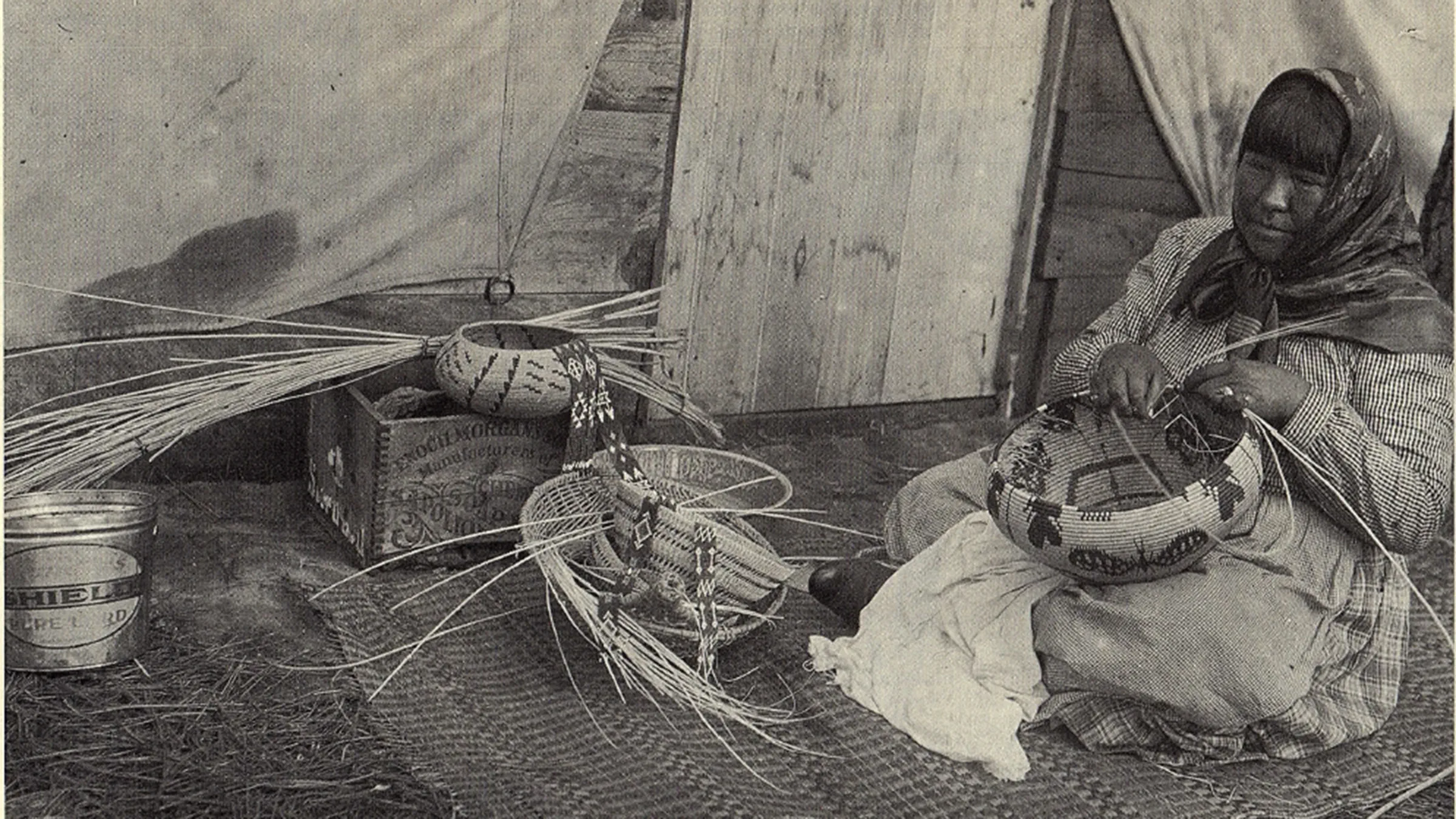 Image of a Washoe woman weaving baskets circa 1915