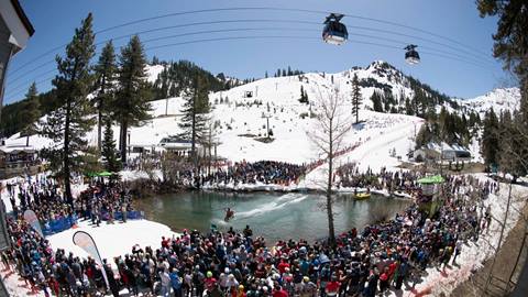 Cushing Crossing skier skiing across the pond with crowd in foreground at the Spring Skiing Capital