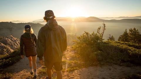 A couple enjoys a sunset hike through Shirley Canyon at Squaw Valley in the summer