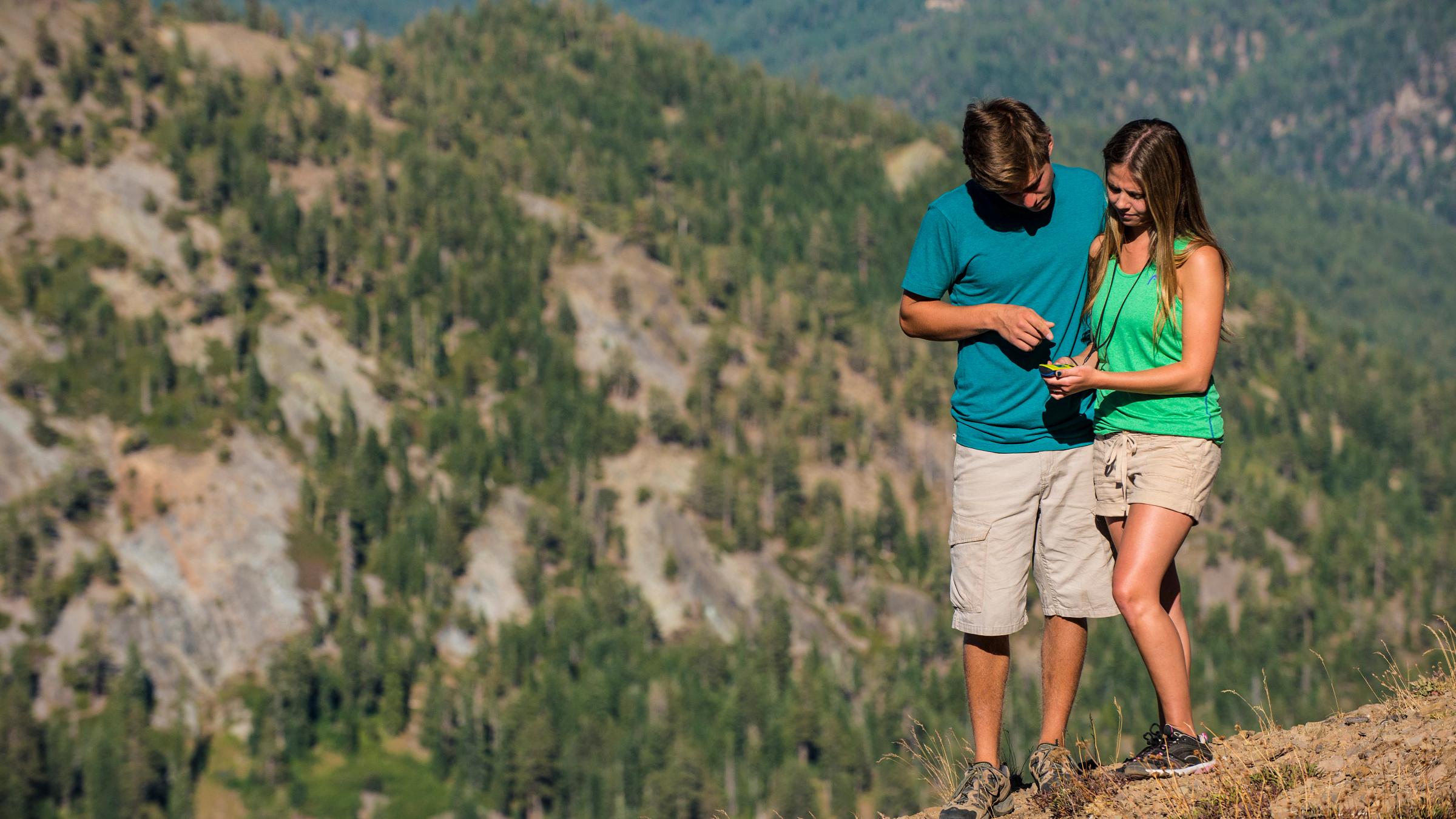 A couple geocaching on a scenic overlook at Squaw Valley