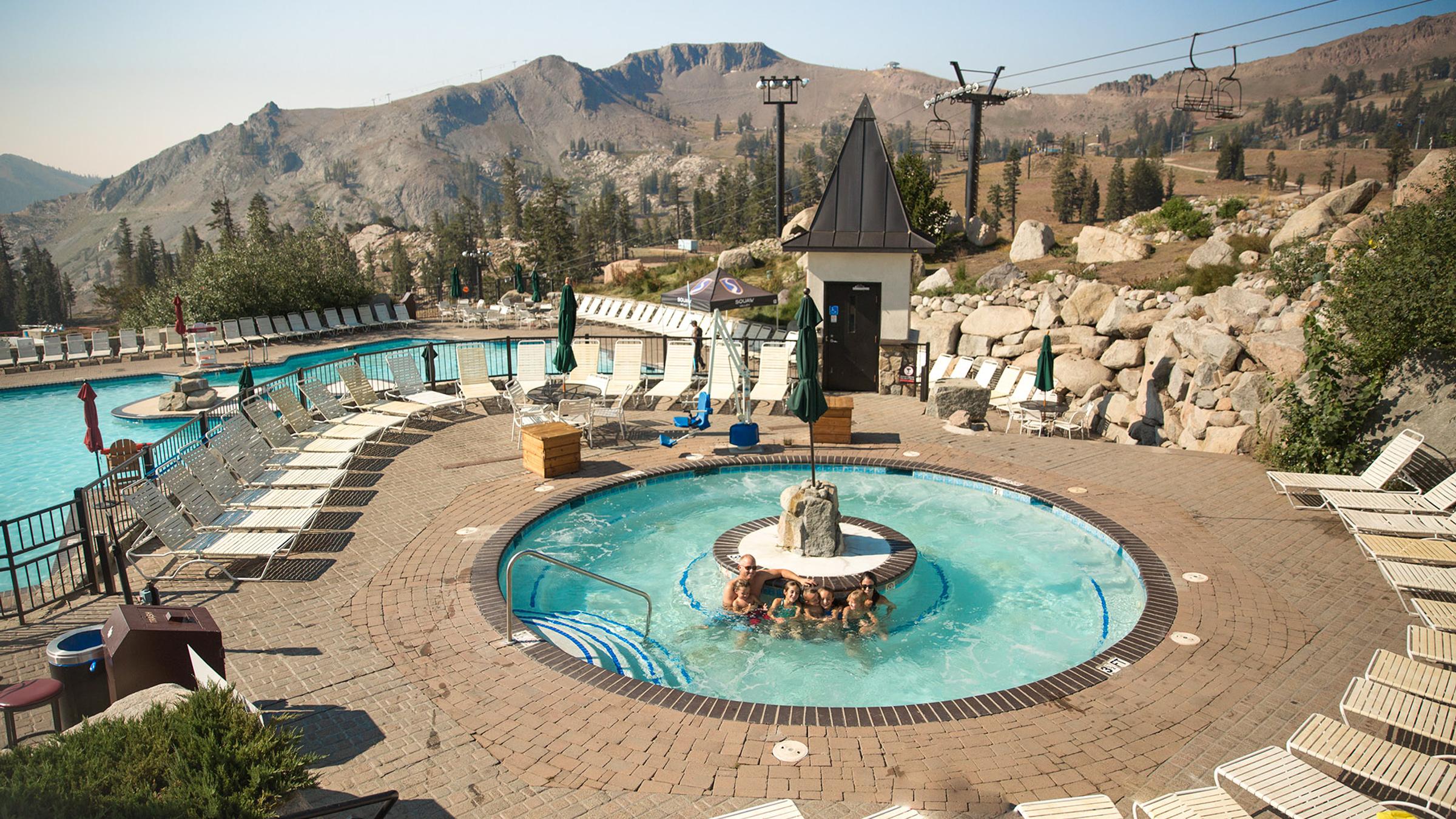 A family enjoying the hot tub on a summer day at the High Camp Pool