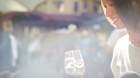Woman holding a souvenir wine glass from Alpen Wine Fest