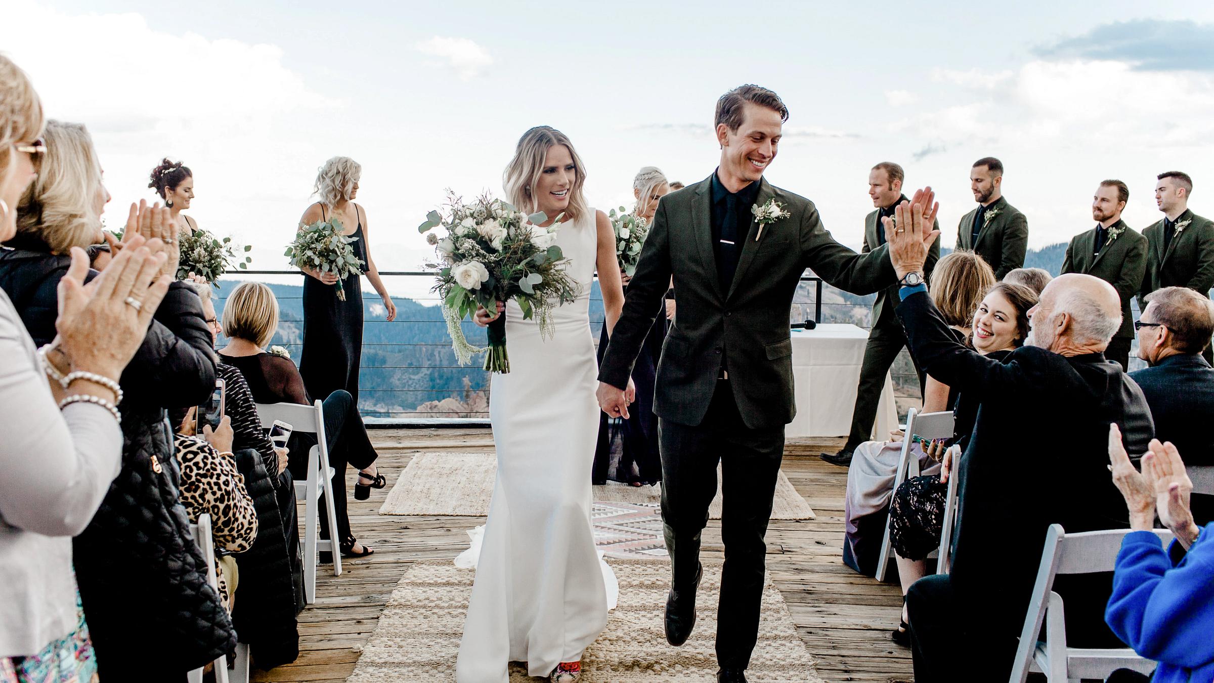 Bride and Groom walking down the isle after getting married on High Camp Deck