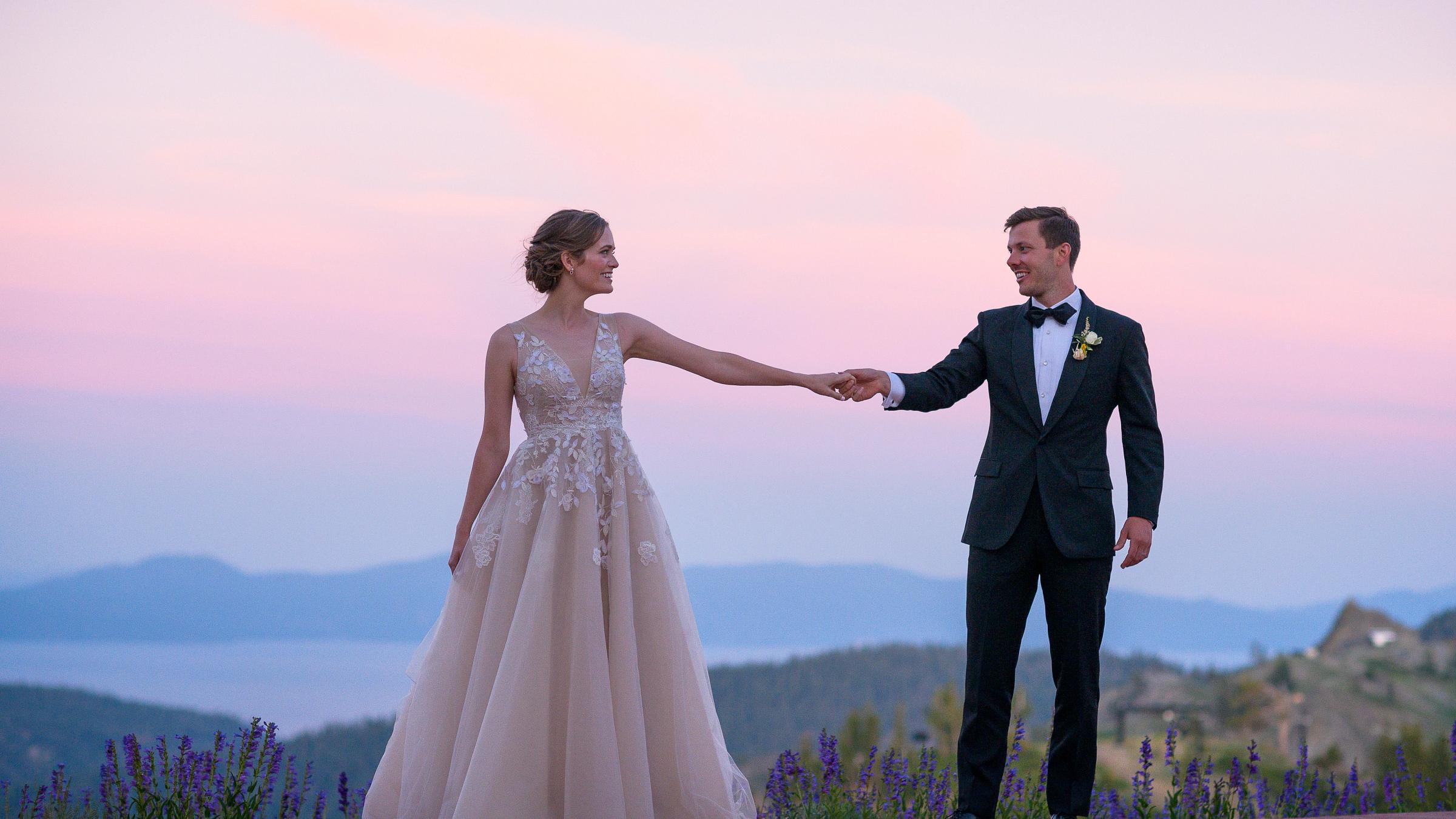Bride and Groom holding hands at sunset at High Camp with Lake Tahoe in the background