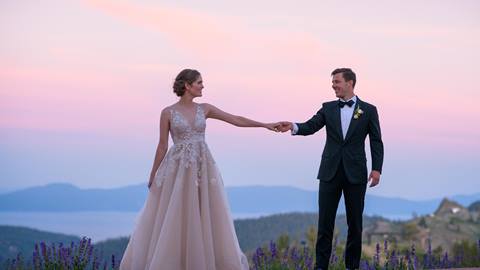 Bride and Groom holding hands at sunset at High Camp with Lake Tahoe in the background