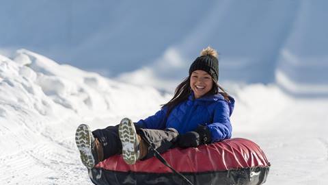A girl enjoys snowtubing at Palisades Tahoe