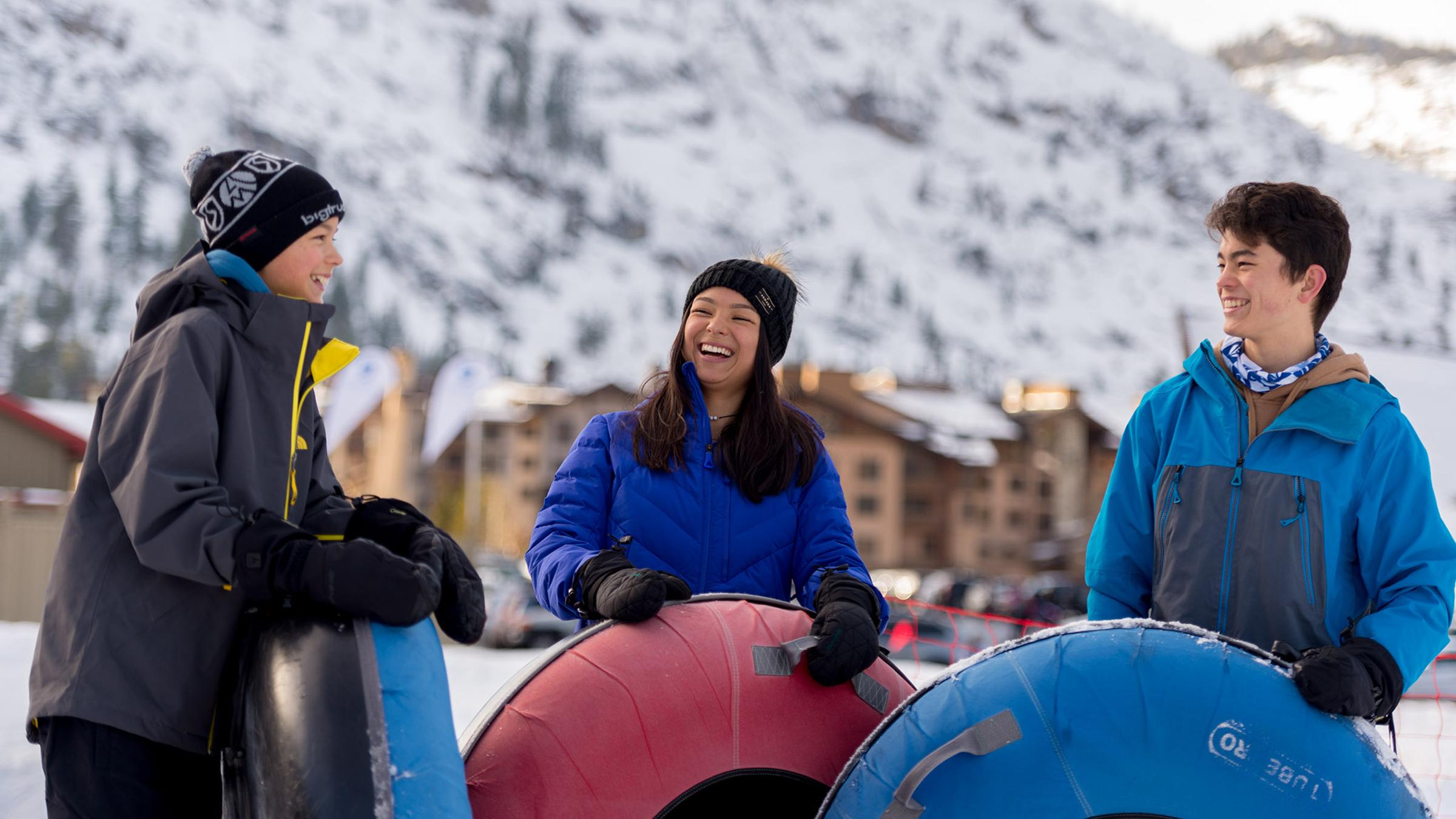 A family Snow Tubing at Squaw Valley with village in the backgroud