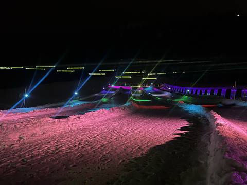 Neon lights shine on two tubing lanes at Palisades Tahoe. 