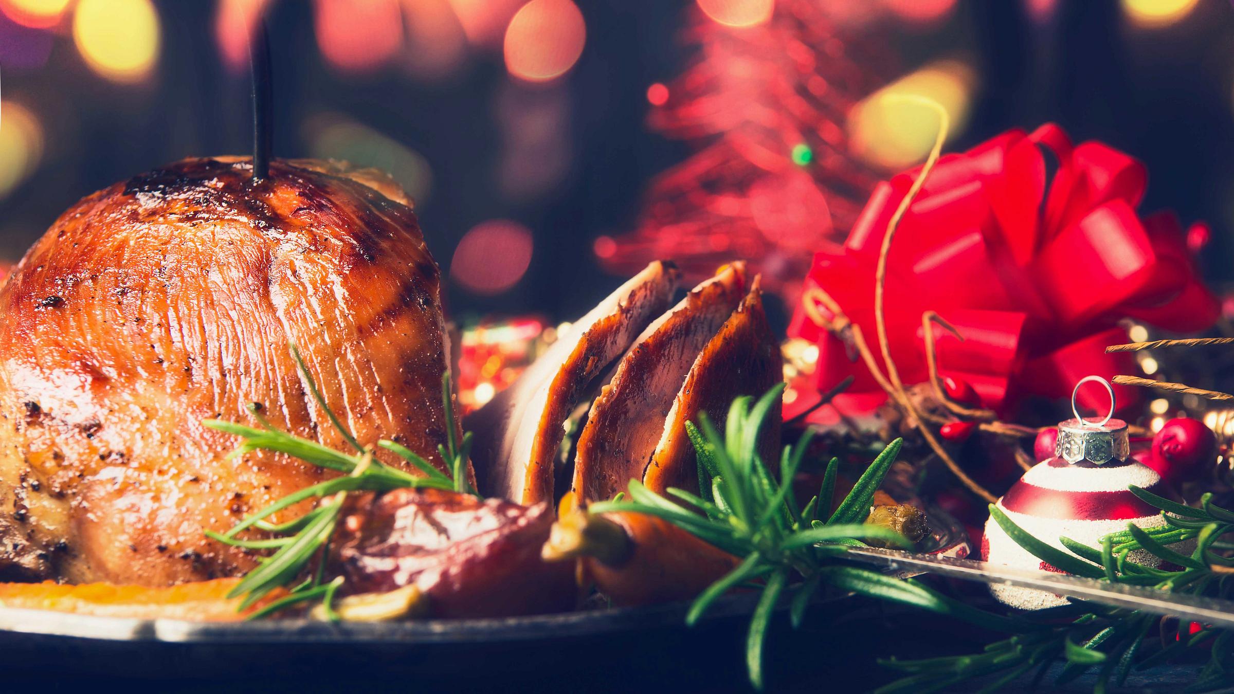 Festive Christmas table with backed ham and decoration.
