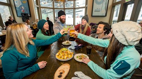 A group of friends toast at Plaza Bar in Squaw Valley, which looks out over Red Dog & KT-22.