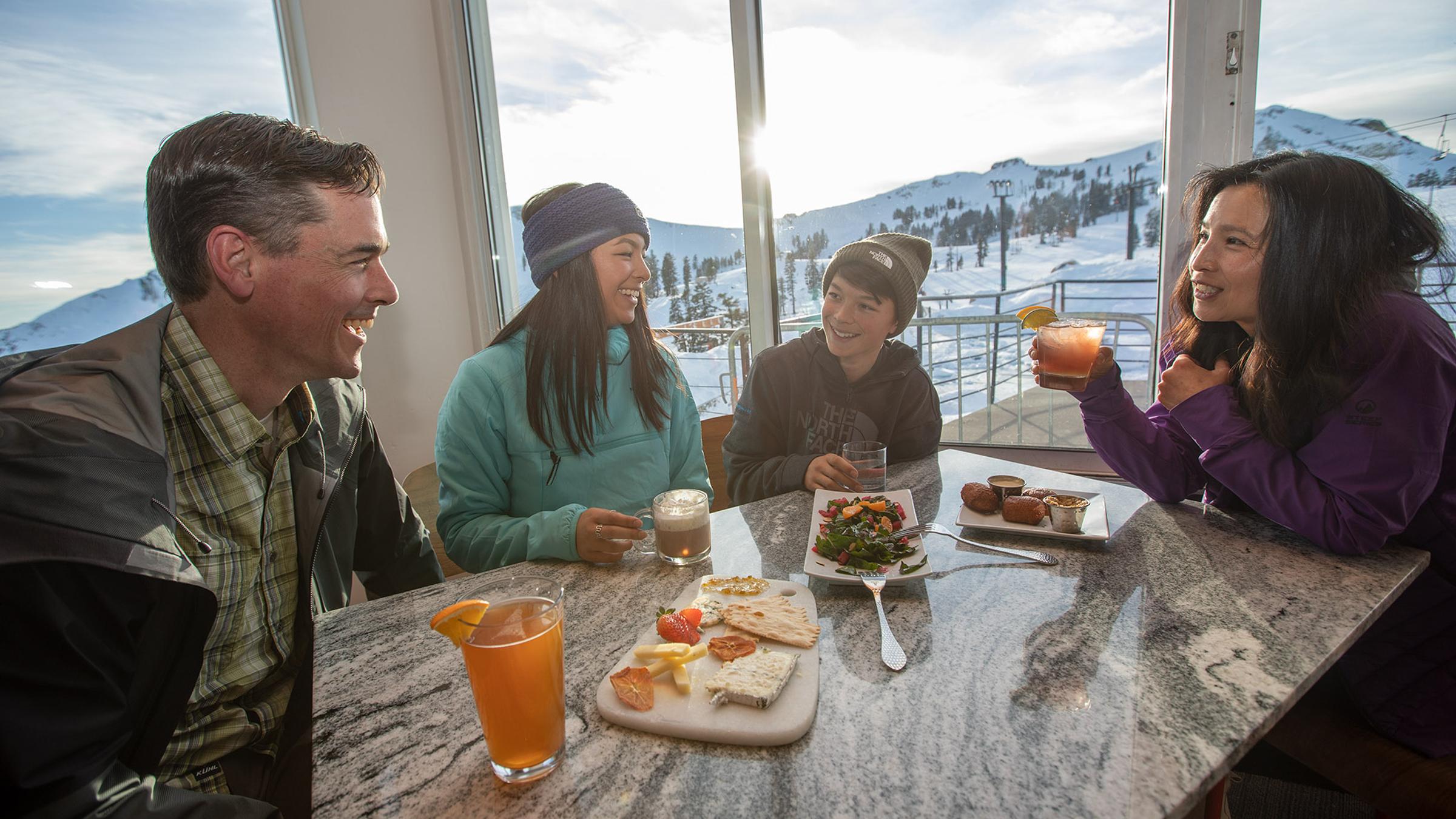 A family enjoys a meal during sunset at Granite Bistro at Squaw Valley's High Camp.