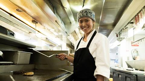 A female cook on the food line in the kitchen at Squaw Valley