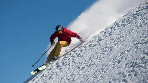 A skier Skiing powder off Silverado on an epic powder day at Squaw Valley