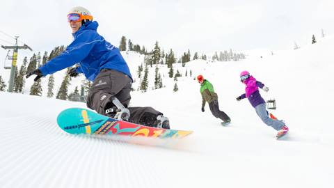 A couple enjoying a snowboard lesson on a fresh groomer at Alpine Meadows