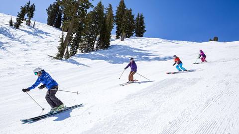 A group of women enjoying a ski lesson on a Shirley Lake groomer at Squaw Valley