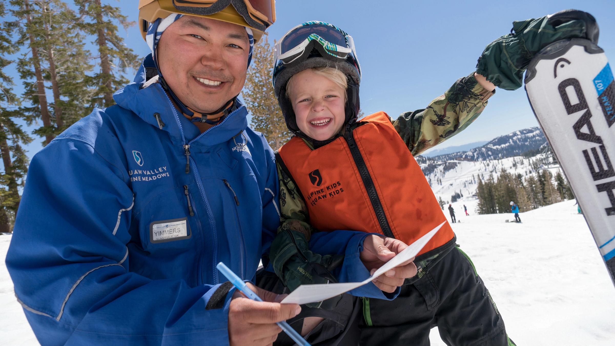 Ski Instructor and child smile while holding an evaluation at Squaw Valley Alpine Meadows