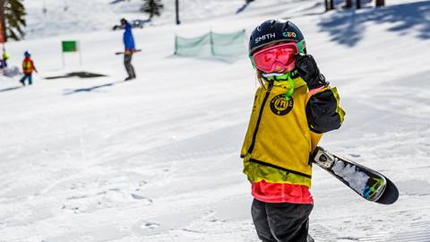 A child smiling during a lesson at Alpine Kids ski & snowboard school at Alpine Meadows