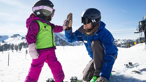 Ski Instructor and child giving a high five