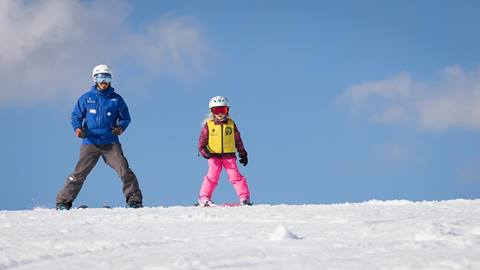 Ski Instructor guiding the child down the slope at Squaw Valley Alpine Meadows