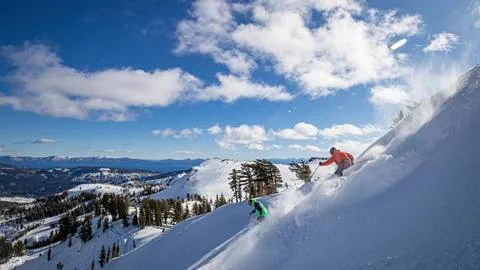A guide and client skiing a powder bowl at Squaw Valley Alpine Meadows