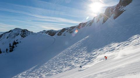 Skiers on groomed run off Siberia at Squaw Valley