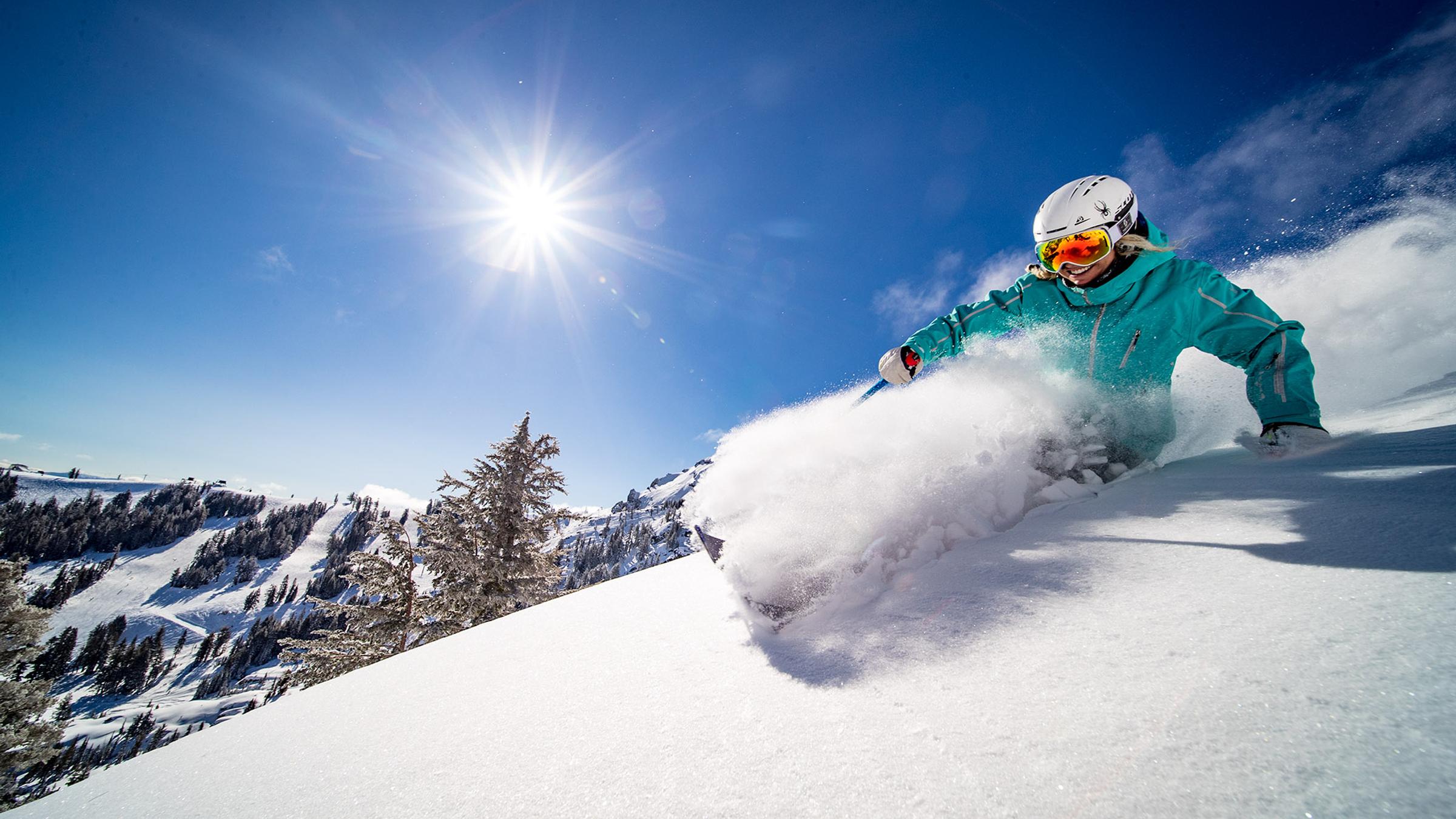 Amie Engerbretson skiing powder on a bluebird day at Palisades Tahoe.