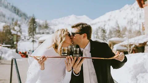 Bride and Groom kiss before a shot ski on the Rocker deck at the Village at Squaw Valley